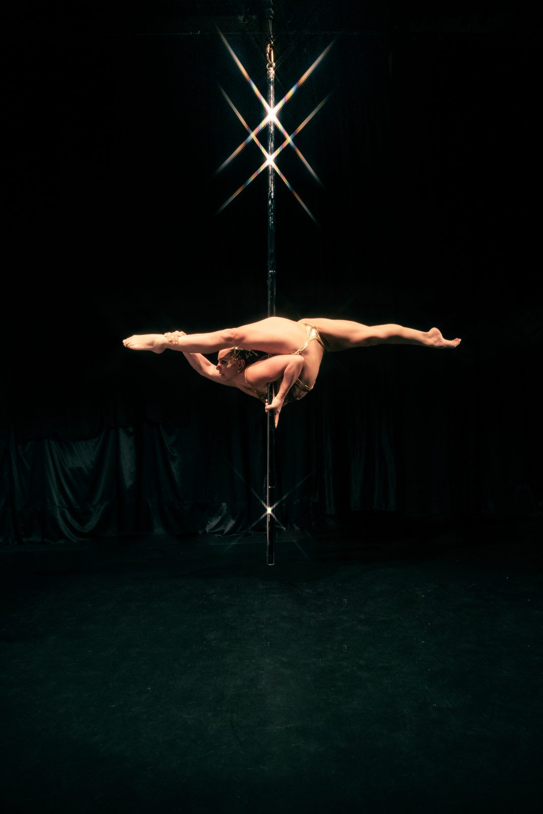 Aerialist performing on a suspended aerial pole