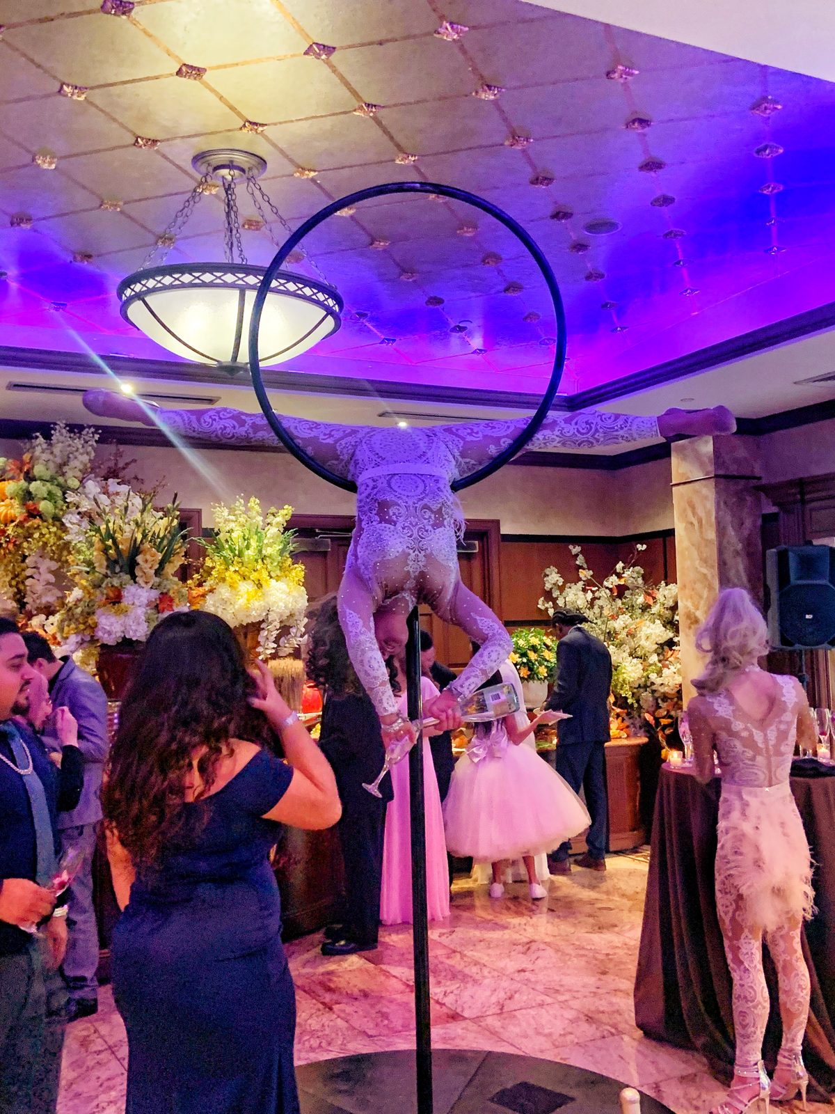 Aerialist on a hoop above event guests