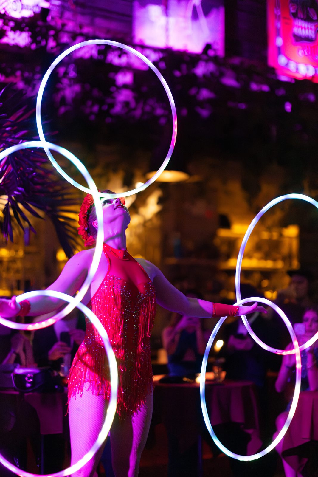 Performer spinning multiple glowing LED hoops