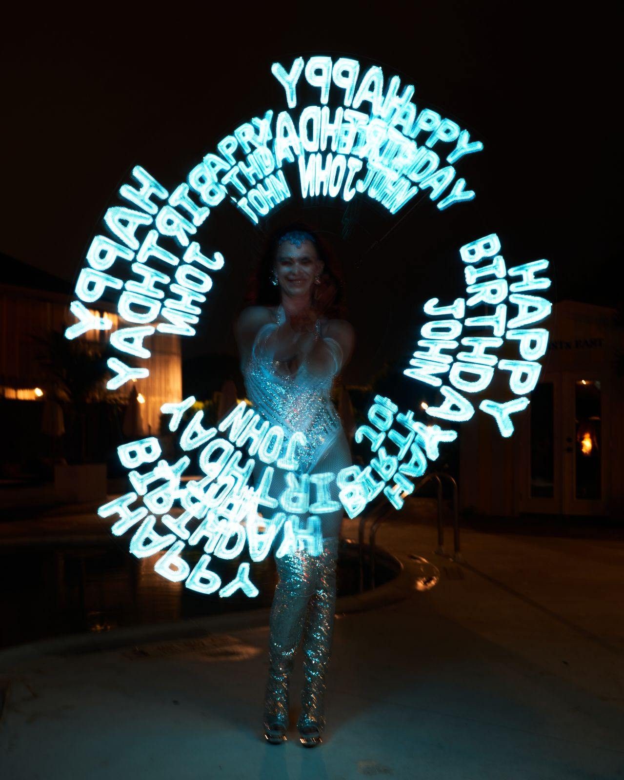 Long-exposure LED poi light-writing spelling Happy Birthday in mid-air