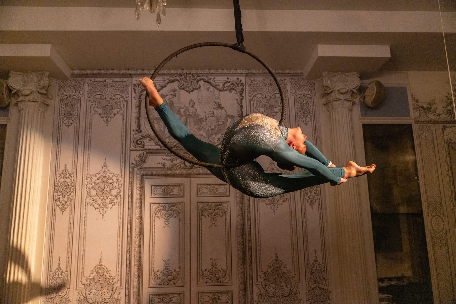 Split on the aerial hoop in an ornate ballroom